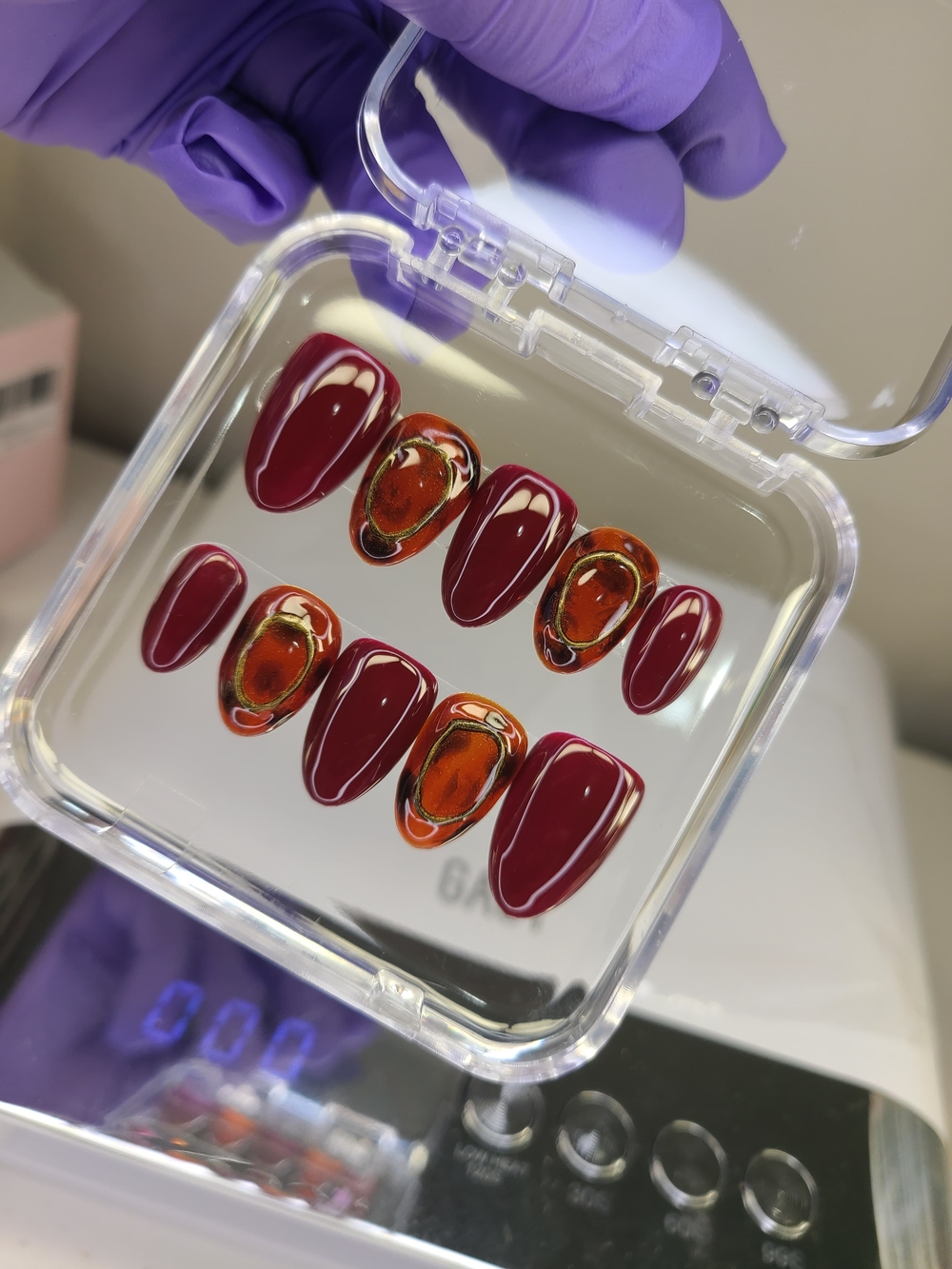 Size(M) Short Almond shape press on nails In Burgundy with accent designs.